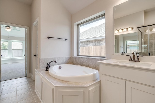 bathroom with ceiling fan, lofted ceiling, a garden tub, tile patterned flooring, and vanity