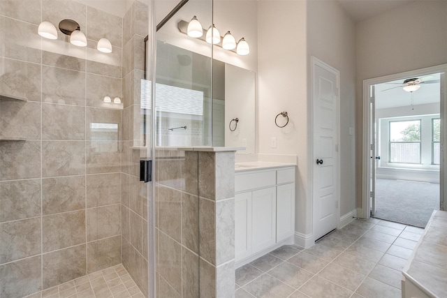 full bathroom with a stall shower, baseboards, ceiling fan, tile patterned floors, and vanity