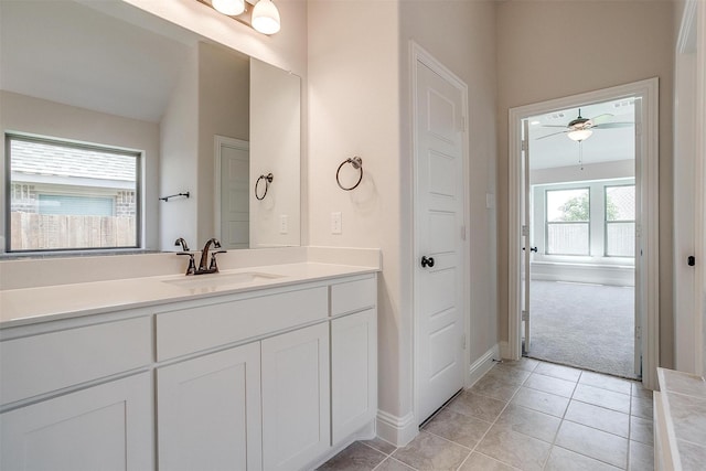 bathroom featuring baseboards, ceiling fan, tile patterned flooring, vaulted ceiling, and vanity