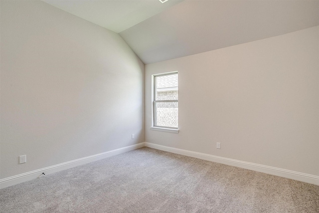 empty room featuring carpet floors and vaulted ceiling