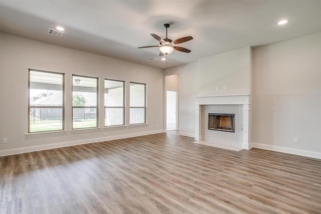 unfurnished living room featuring light wood-type flooring, ceiling fan, and a fireplace