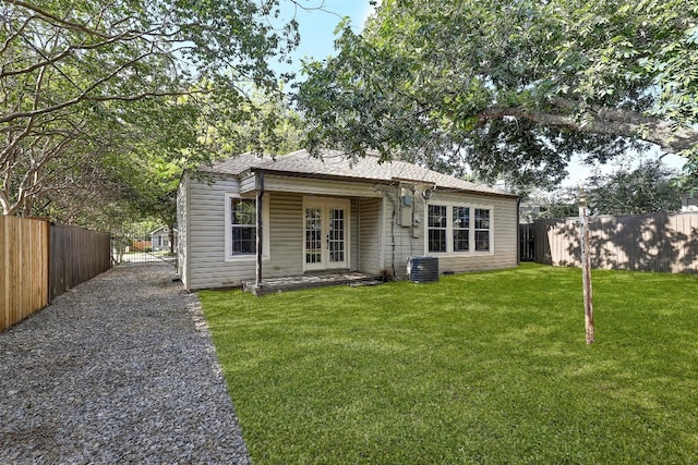 back of house featuring a lawn and french doors