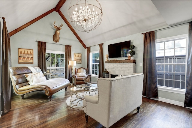 living room with plenty of natural light, dark hardwood / wood-style floors, an inviting chandelier, and a brick fireplace