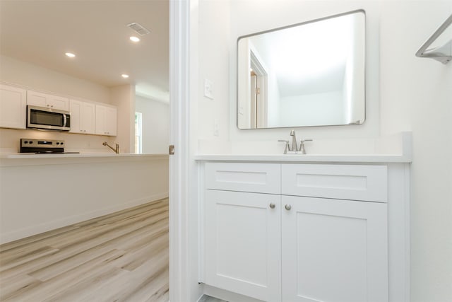 338 N Moore St, Dallas, TX 75203 - bathroom featuring vanity, recessed lighting, and wood finished floors