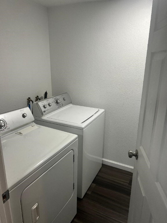 clothes washing area featuring washer hookup, dark hardwood / wood-style flooring, and washing machine and clothes dryer