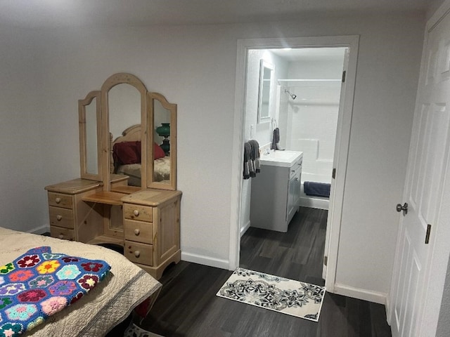 bedroom featuring ensuite bath, dark hardwood / wood-style flooring, and sink