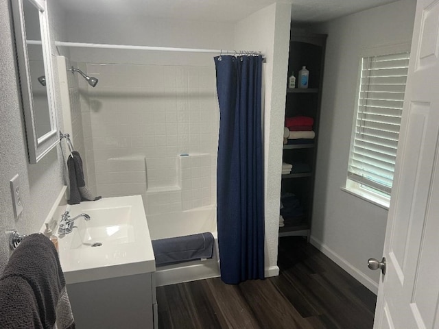 bathroom featuring hardwood / wood-style floors, vanity, and shower / bath combo with shower curtain