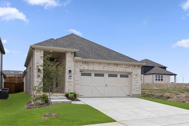 view of front of house featuring a garage, a front lawn, and central air condition unit