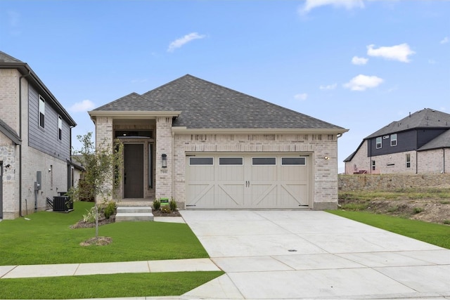 view of front of house featuring central AC, a garage, and a front yard