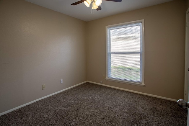 unfurnished room featuring ceiling fan, dark colored carpet, and a wealth of natural light