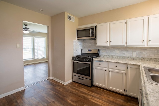 kitchen with ceiling fan, backsplash, dark wood-type flooring, and stainless steel appliances