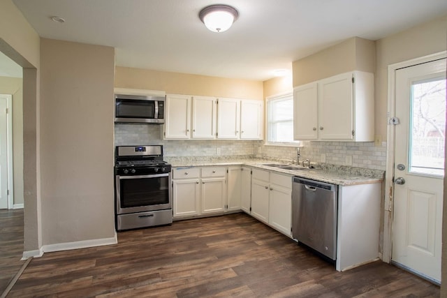 kitchen with white cabinets, backsplash, stainless steel appliances, and dark hardwood / wood-style flooring