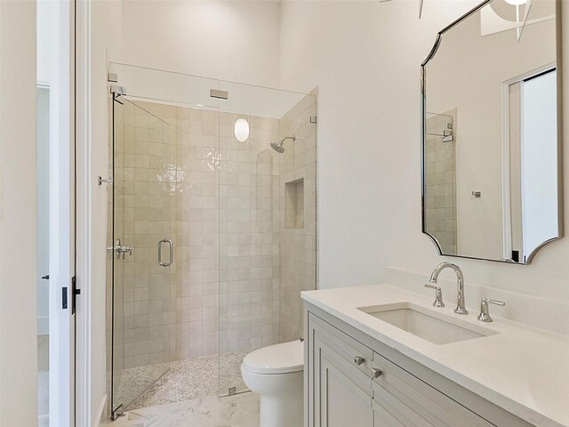 bathroom featuring walk in shower, vanity, and toilet