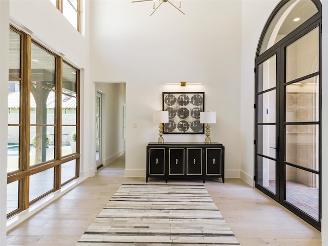 interior space with light wood-type flooring and a high ceiling