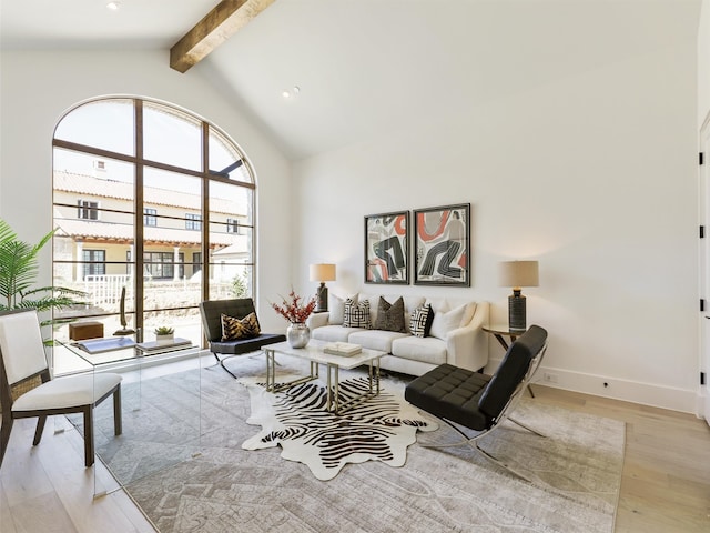 living room featuring beamed ceiling, light hardwood / wood-style flooring, and high vaulted ceiling