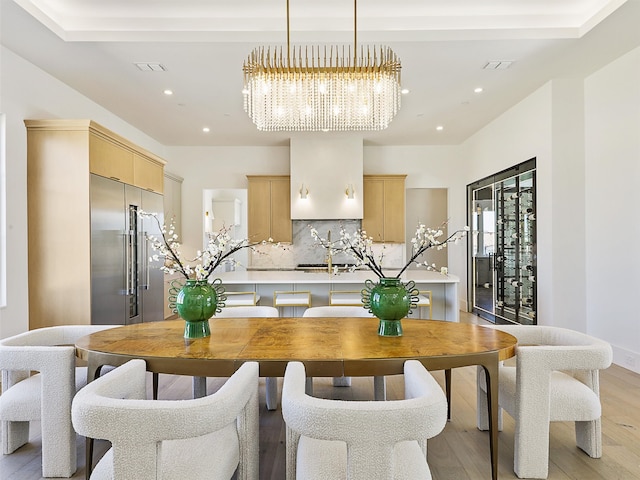 kitchen with light brown cabinets, appliances with stainless steel finishes, light wood-type flooring, and tasteful backsplash