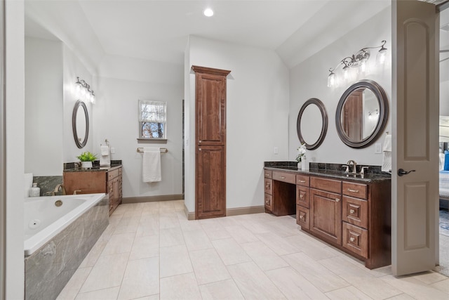 bathroom with tile patterned floors, tiled bath, and vanity