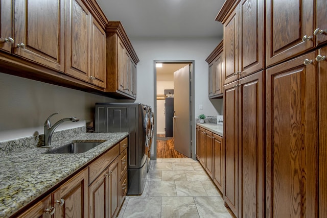 clothes washing area with cabinets, separate washer and dryer, and sink