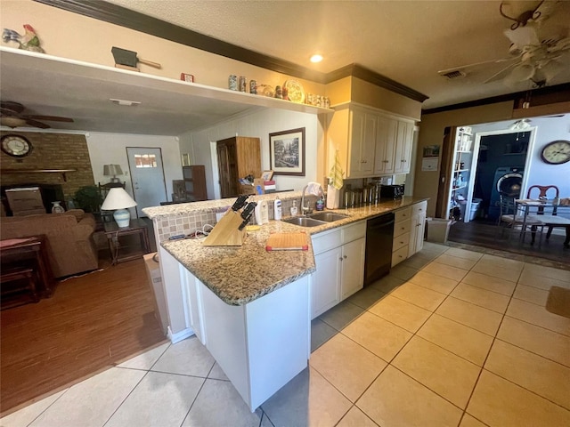 kitchen with white cabinetry, ceiling fan, sink, and a fireplace