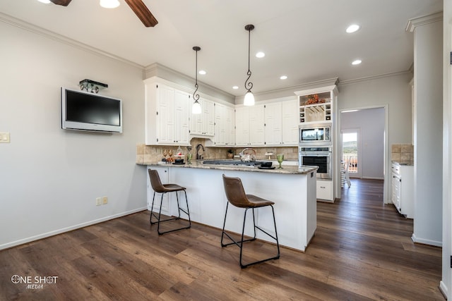 kitchen featuring pendant lighting, white cabinets, kitchen peninsula, and stainless steel appliances