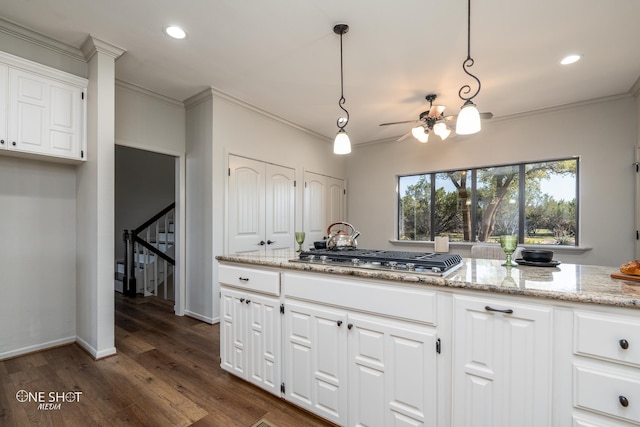 kitchen featuring light stone counters, ceiling fan, decorative light fixtures, white cabinetry, and stainless steel gas stovetop