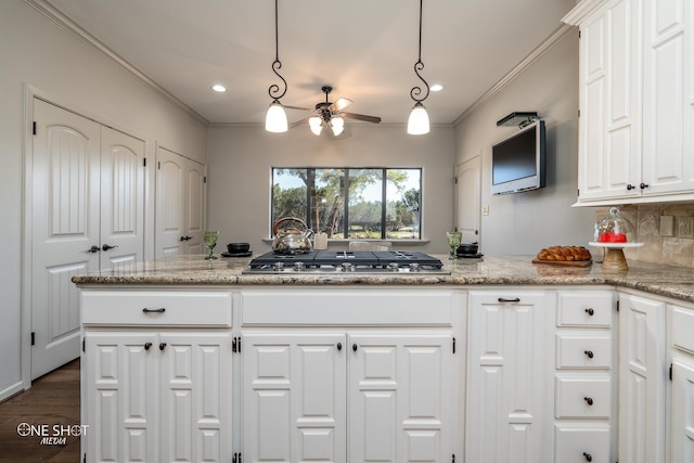 kitchen featuring light stone countertops, hanging light fixtures, stainless steel gas cooktop, tasteful backsplash, and white cabinets