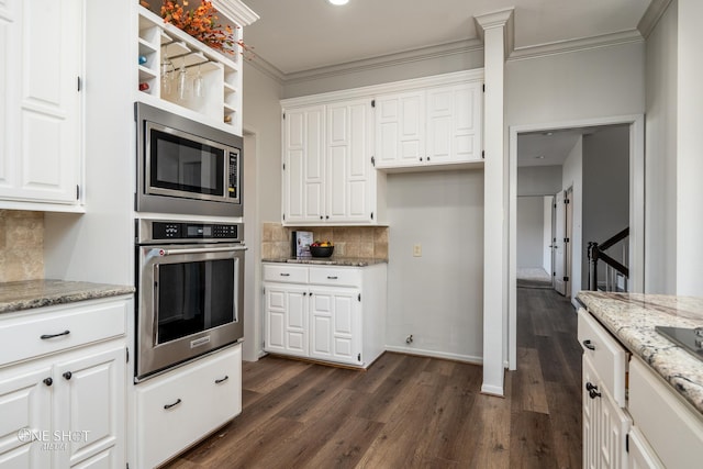 kitchen with white cabinetry, stainless steel appliances, light stone counters, decorative backsplash, and ornamental molding