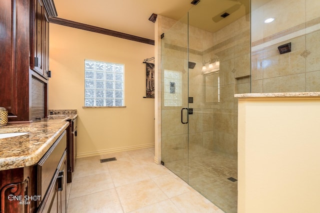 bathroom with vanity, tile patterned floors, a shower with shower door, and crown molding