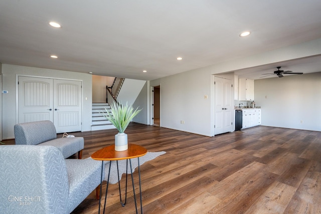 living room featuring ceiling fan and dark wood-type flooring