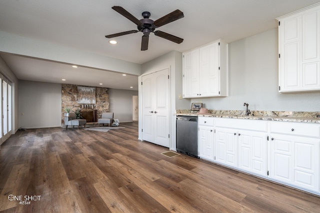 kitchen with white cabinetry, a fireplace, stainless steel dishwasher, and sink