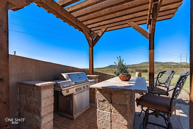 view of patio featuring a pergola, an outdoor kitchen, and an outdoor bar