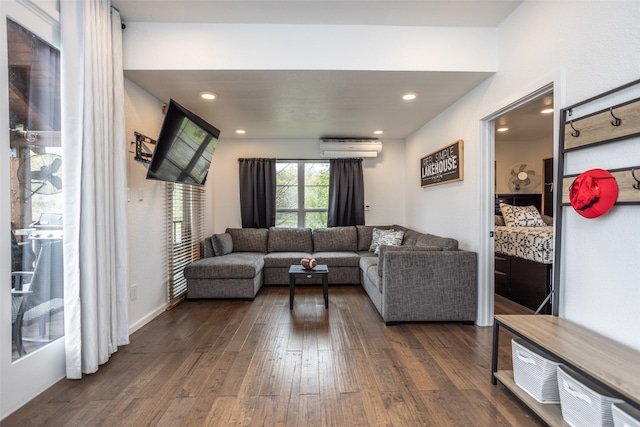 living room with dark hardwood / wood-style floors and a wall unit AC