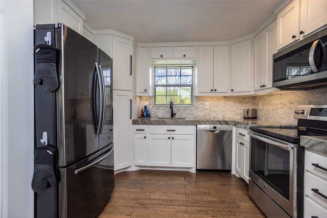 kitchen featuring dark hardwood / wood-style floors, sink, appliances with stainless steel finishes, tasteful backsplash, and white cabinetry