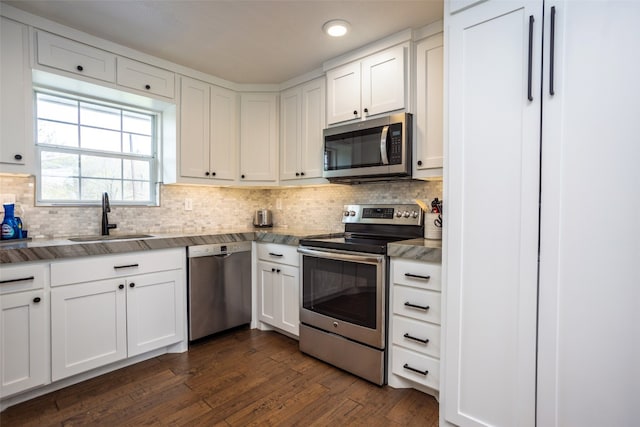 kitchen with white cabinetry, stainless steel appliances, sink, and dark hardwood / wood-style flooring