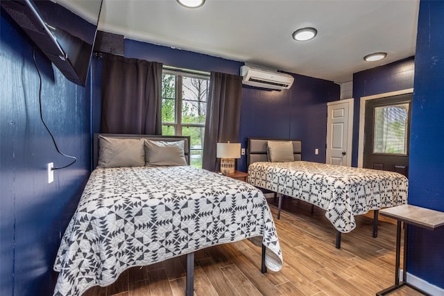 bedroom featuring wood-type flooring and a wall mounted AC