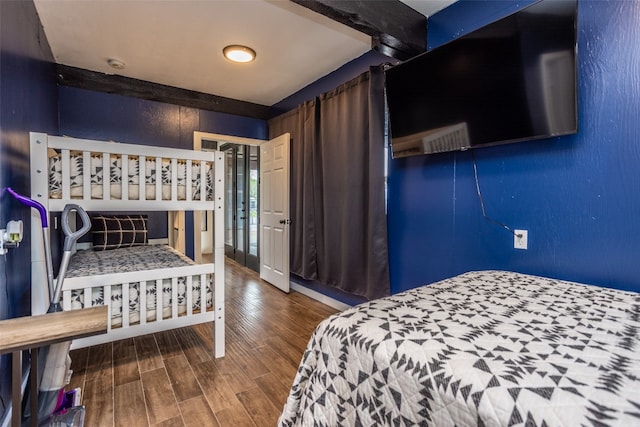 bedroom featuring beamed ceiling and dark hardwood / wood-style flooring