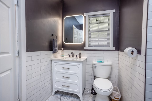 bathroom featuring tile walls, tile floors, toilet, and vanity