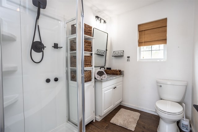 bathroom with toilet, vanity, walk in shower, and wood-type flooring