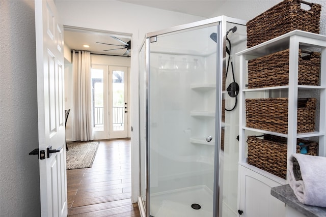 bathroom featuring a shower with door, ceiling fan, and hardwood / wood-style floors