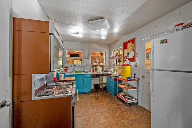 68 Zumwalt Ln, Pottsboro, TX 75076 - kitchen with freestanding refrigerator, stainless steel electric range oven, concrete flooring, a textured ceiling, and blue cabinets