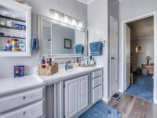 bathroom featuring crown molding, vanity, and hardwood / wood-style floors