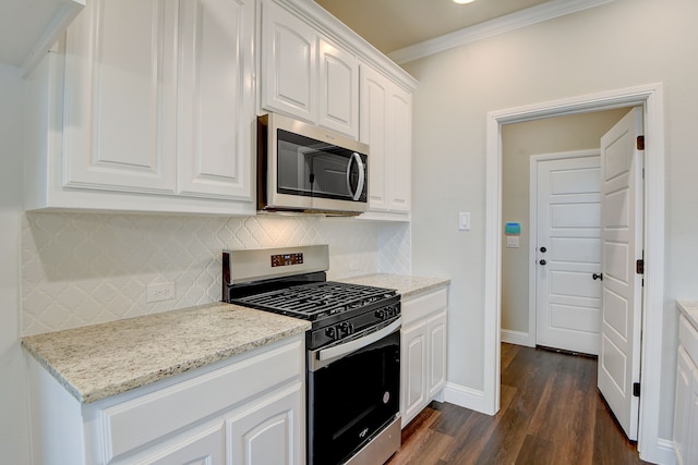 kitchen featuring appliances with stainless steel finishes, decorative backsplash, white cabinets, crown molding, and dark hardwood / wood-style floors