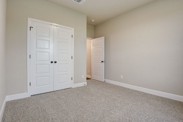 unfurnished bedroom featuring carpet and a closet