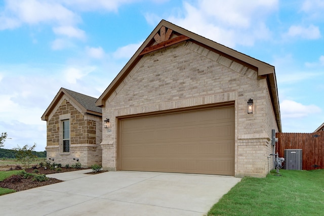 view of front of house with a garage, central air condition unit, and a front yard