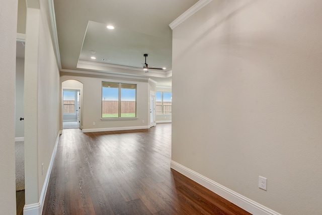 hall with a raised ceiling, hardwood / wood-style flooring, and crown molding