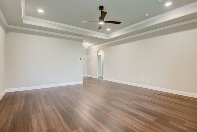 spare room with dark hardwood / wood-style flooring, ceiling fan, a raised ceiling, and crown molding