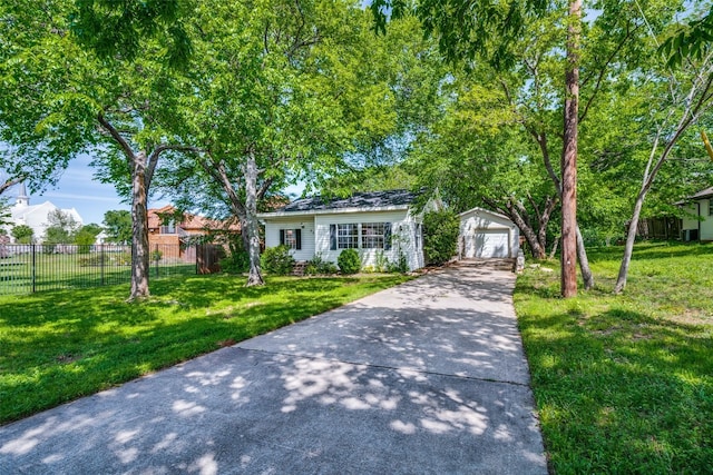 view of front of home featuring an outbuilding, a front lawn, fence, and a garage