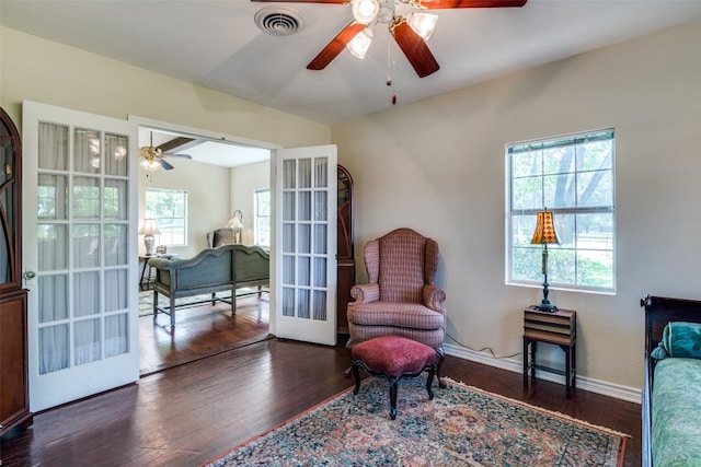 living area featuring dark hardwood / wood-style flooring, ceiling fan, and french doors