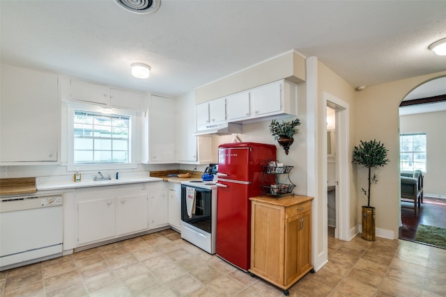 kitchen with white appliances, white cabinets, sink, and light tile floors