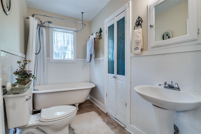 bathroom with tile walls, tile floors, bathtub / shower combination, and toilet